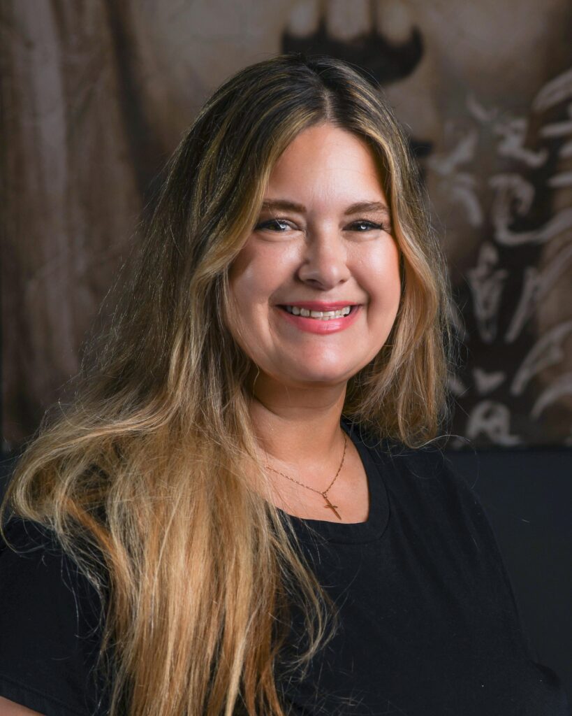 a woman sitting in front of a painting