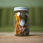 a glass jar filled with cookies sitting on top of a wooden table