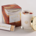 a white candle next to a box of matches