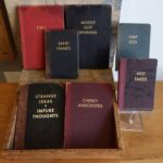 a wooden table topped with lots of different colored books